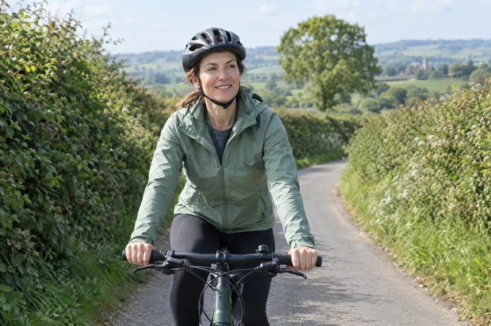 A woman cycling down a country lane