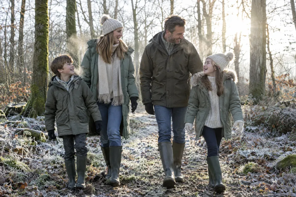 A family walking through frosty woods